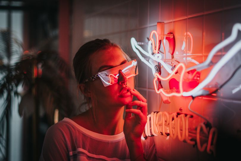 Girl in eyeglasses near the neon light