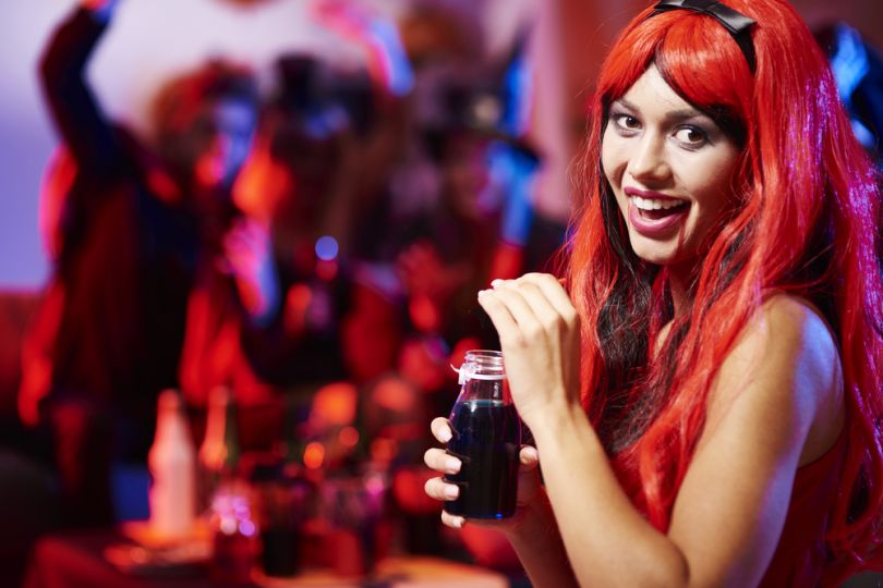 Girl in a red wig with a cocktail