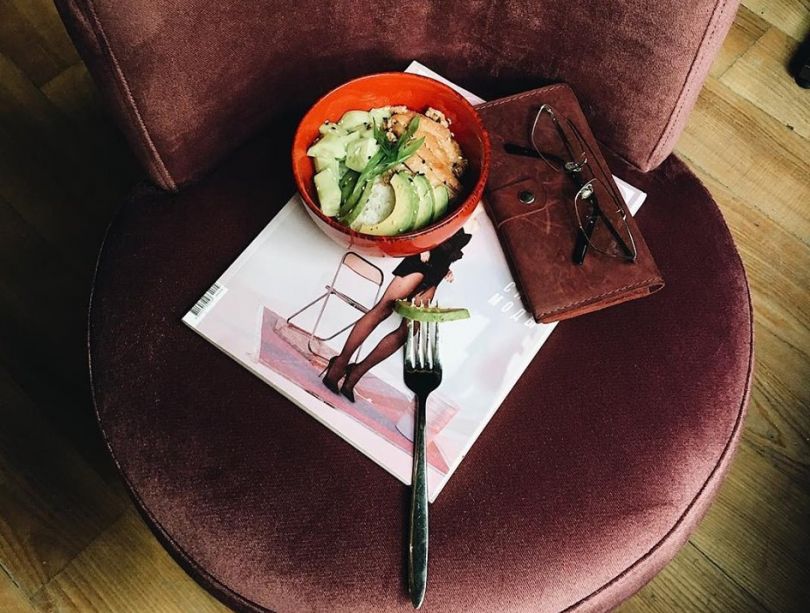 glasses, magazine and dish with salad on table