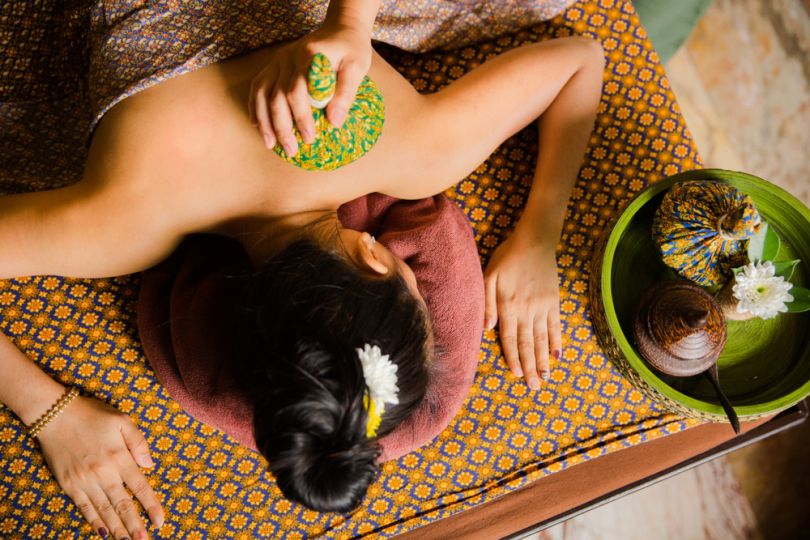 Woman receiving traditional herbal compress treatment