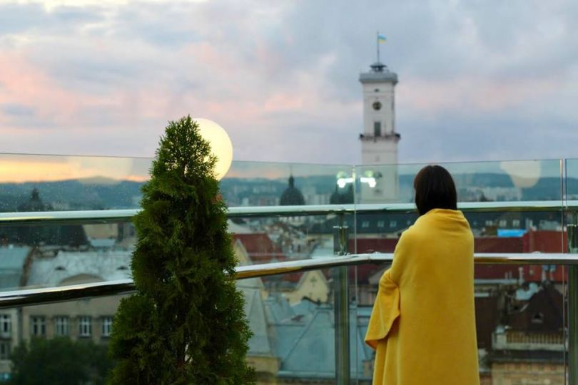 Woman wrapped in a blanket on an open-air terrace