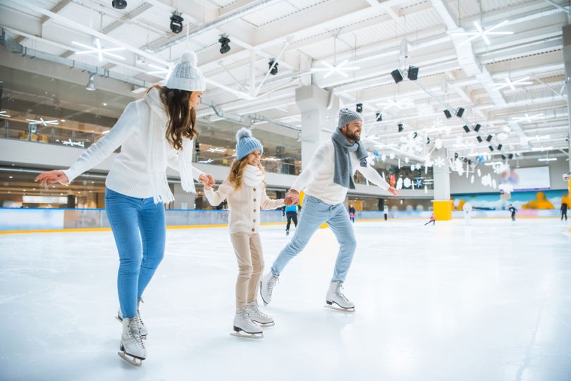 A family skating in an indoors rink