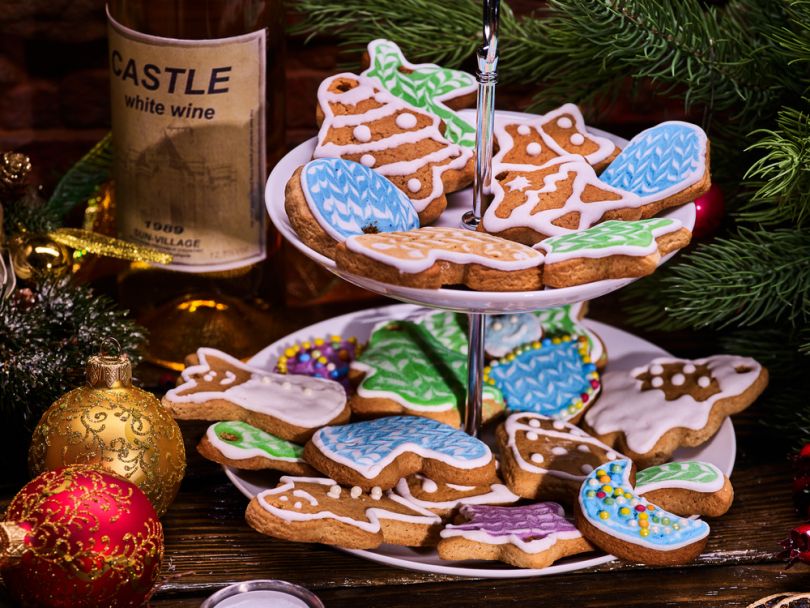 many ginger cookies on two level plate and bottle of wine