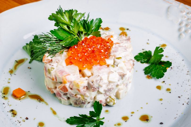 olivier salad with caviar and greenery on plate