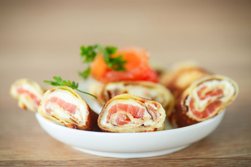 Pancakes with Curd and Salmon and greenery on plate