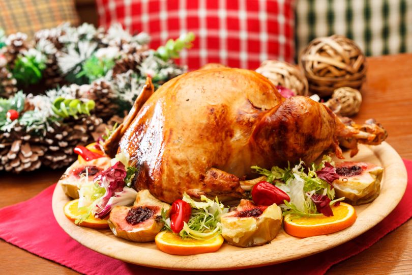 chicken cooked with oranges on plate with new year decorations on background