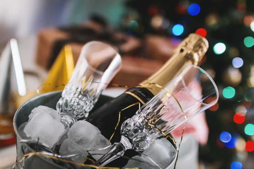 bottle of champagne with two glasses in bucket with ice