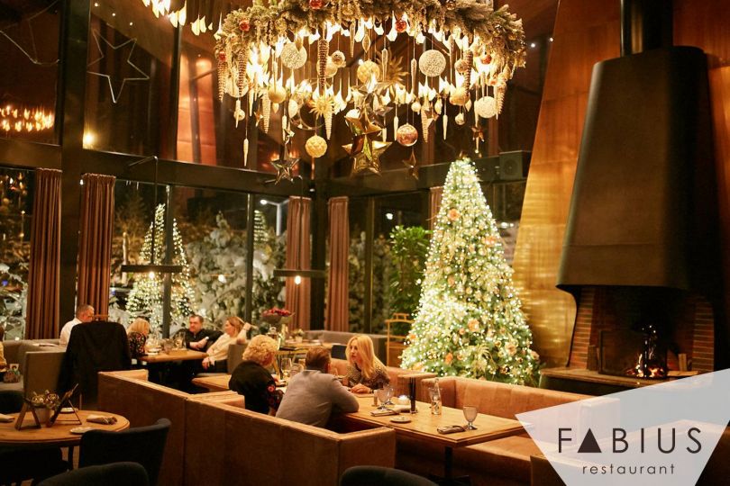 Christmas tree and decorations in restaurant with people
