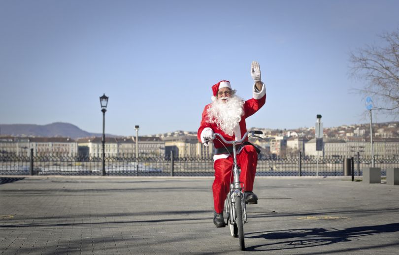 Man in a Santa costume on a bike