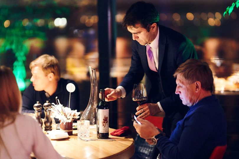 Sommelier brings a bottle of wine