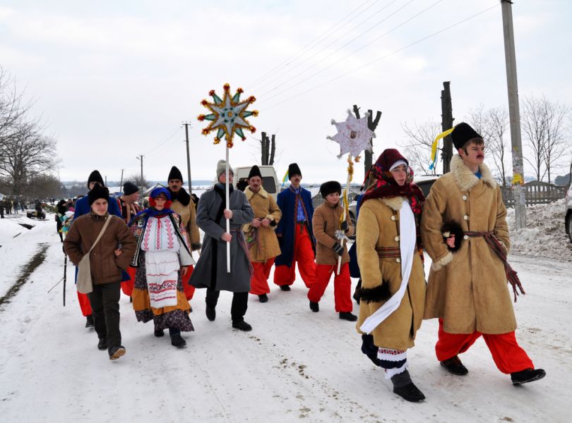 people in traditional ukrainian costumes with christmas symbols outdoor