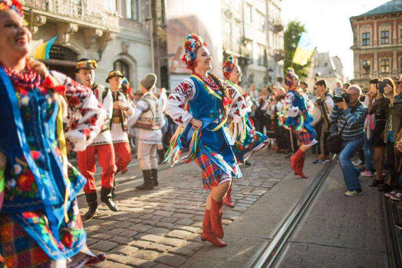 people dancing in national Ukrainian costumes on Lviv street