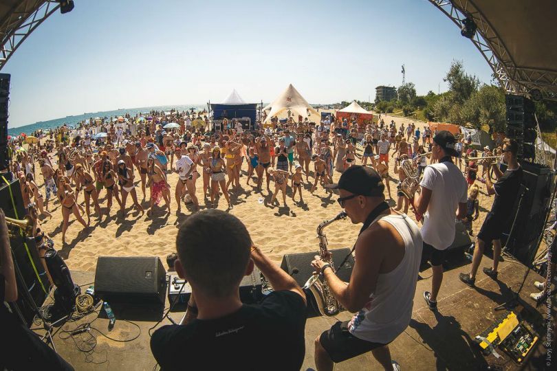 musicians on stage and crowd of listeners on seaside fest