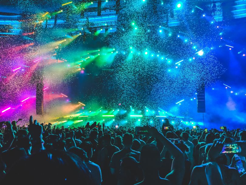crowd dancing on a big party in colorful lights