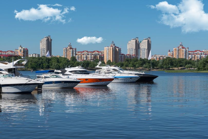 motor boats in river with city on background