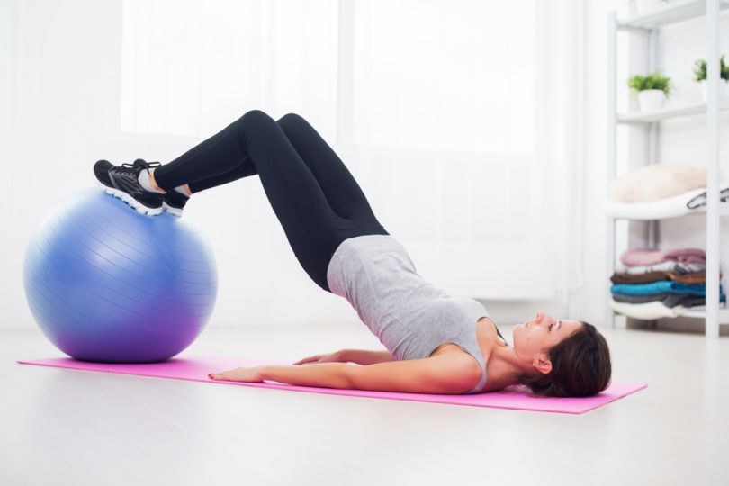girl doing pilates in gym using fitball