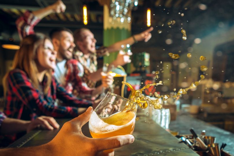 Friends watching football in a pub with beer