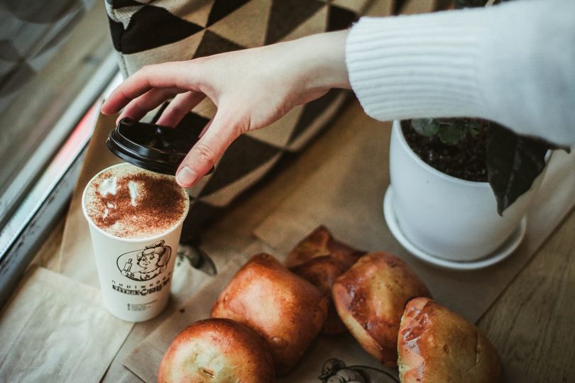 patties and female hand holding cup of coffee