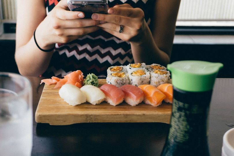 Girl taking a pic of sushi