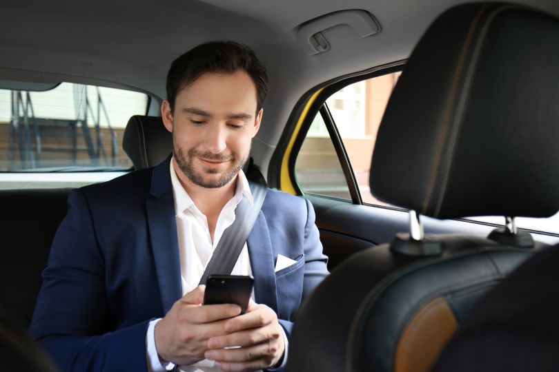 Man checking his phone in taxi