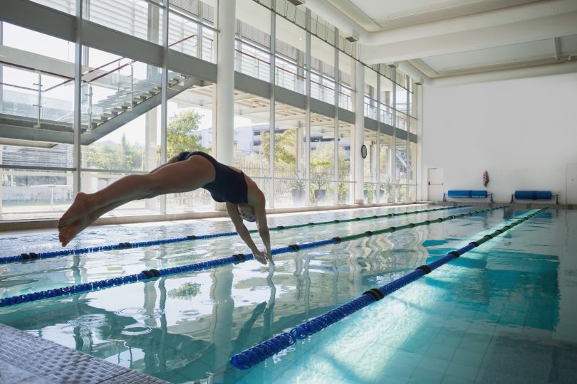 Woman jumping into a pool